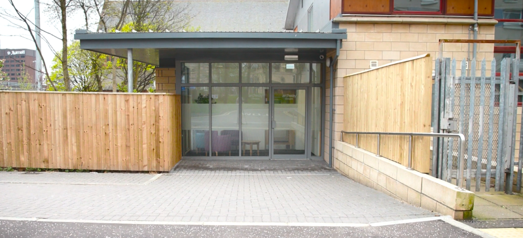 Photograph showing Archway's main entrance on St Vincent Terrace, with the Marriot Hotel in the background, wooden fencing to the left, and metal fencing to the right